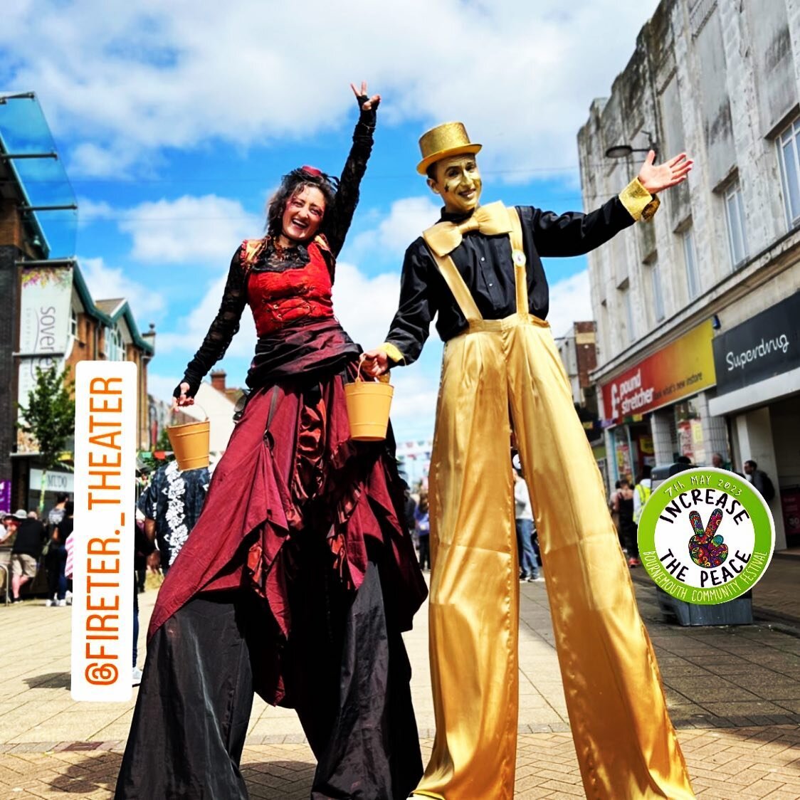 Increase the Peace — two stilt walkers in costume on the high street